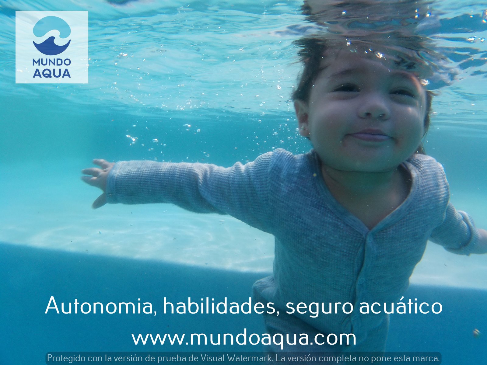 Smiling toddler underwater in Merida Yucatan reaching for a toy
